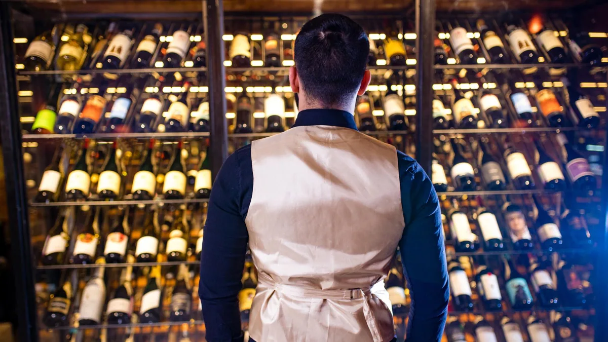 Bouteilles de vin et verre de dégustation posés sur une table, avec étiquettes visibles