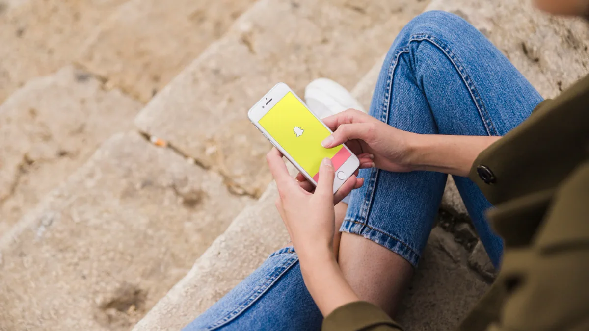 Écran de smartphone affichant Snapchat et un score Snap sur un profil utilisateur