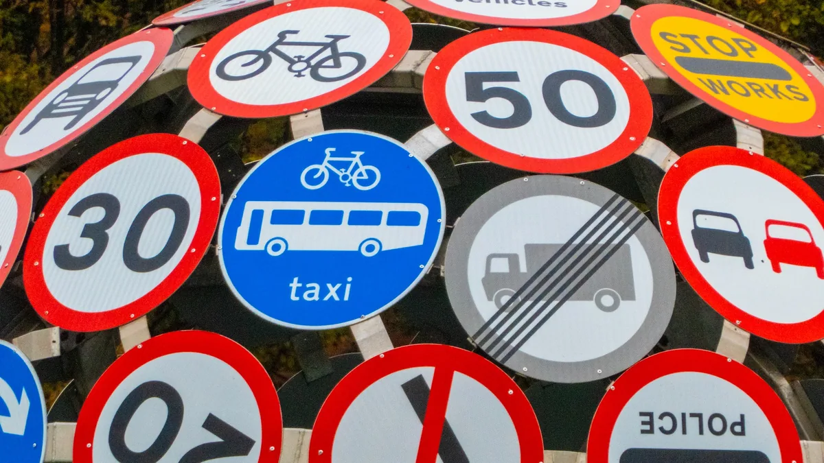 Conducteur consultant une vignette Crit’Air et un panneau de zone à faibles émissions en ville