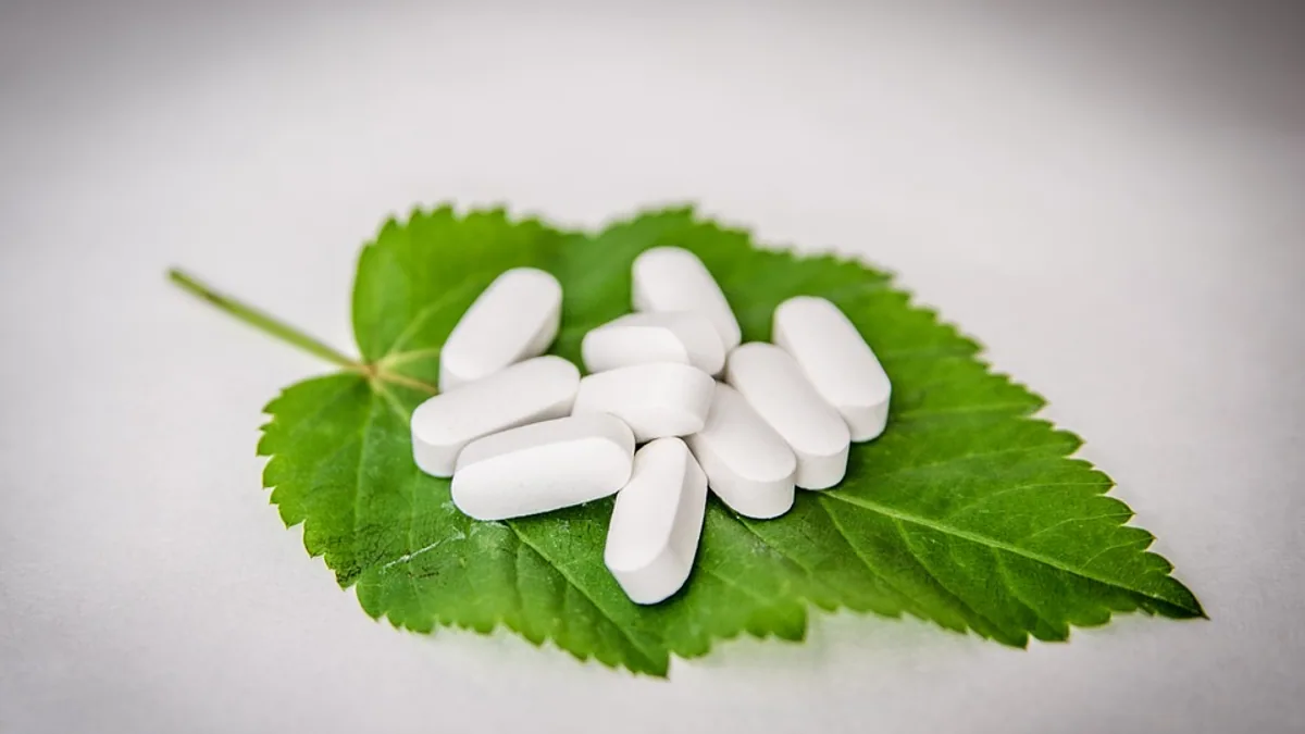Boîtes de médicaments, smartphone et croix verte de pharmacie sur un comptoir