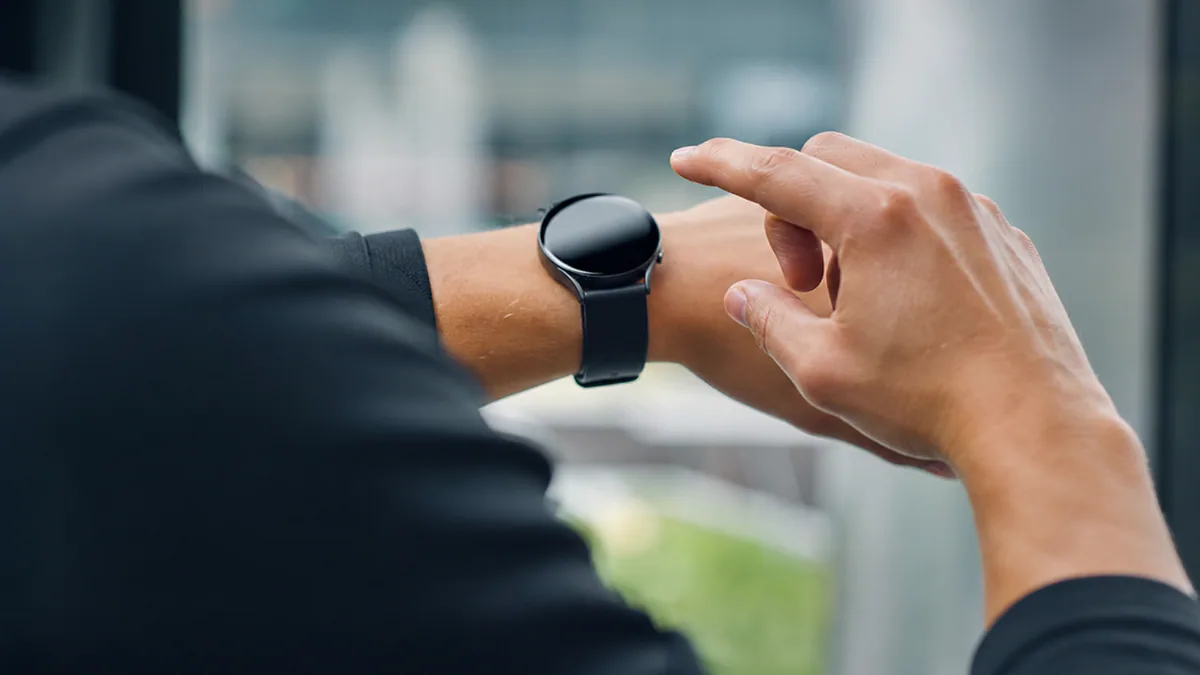 Montre connectée au poignet affichant des données d’activité et réagissant à un mouvement de la main