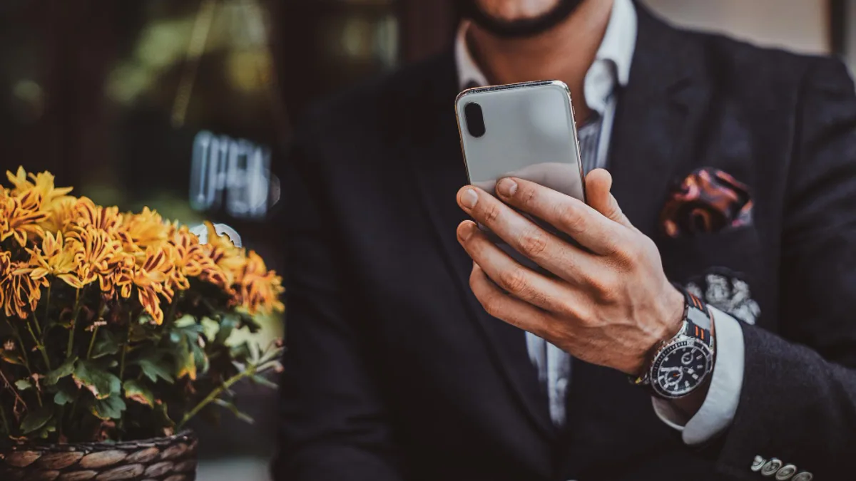Montre de luxe à bracelet acier portée au poignet avec une chemise et une veste élégante