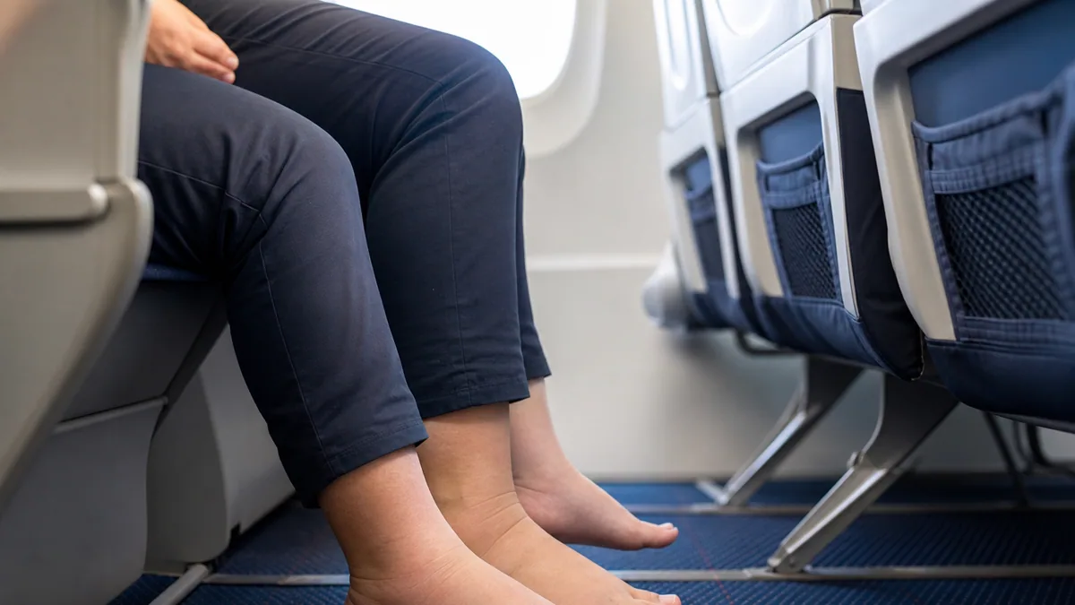 Pieds et jambes d'un passager assis en cabine d'avion pendant un vol