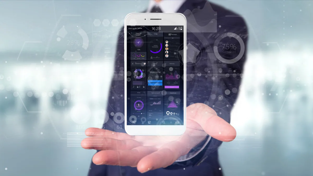 Développeur analysant le budget et les maquettes d’une application mobile sur un ordinateur portable
